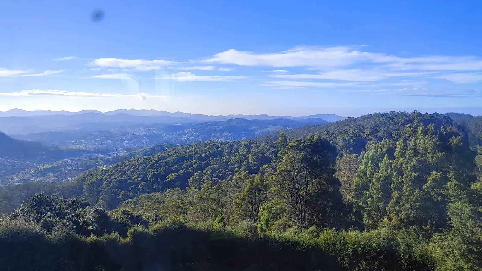 Forested hills of the upper Nilgiris under a clear blue sky