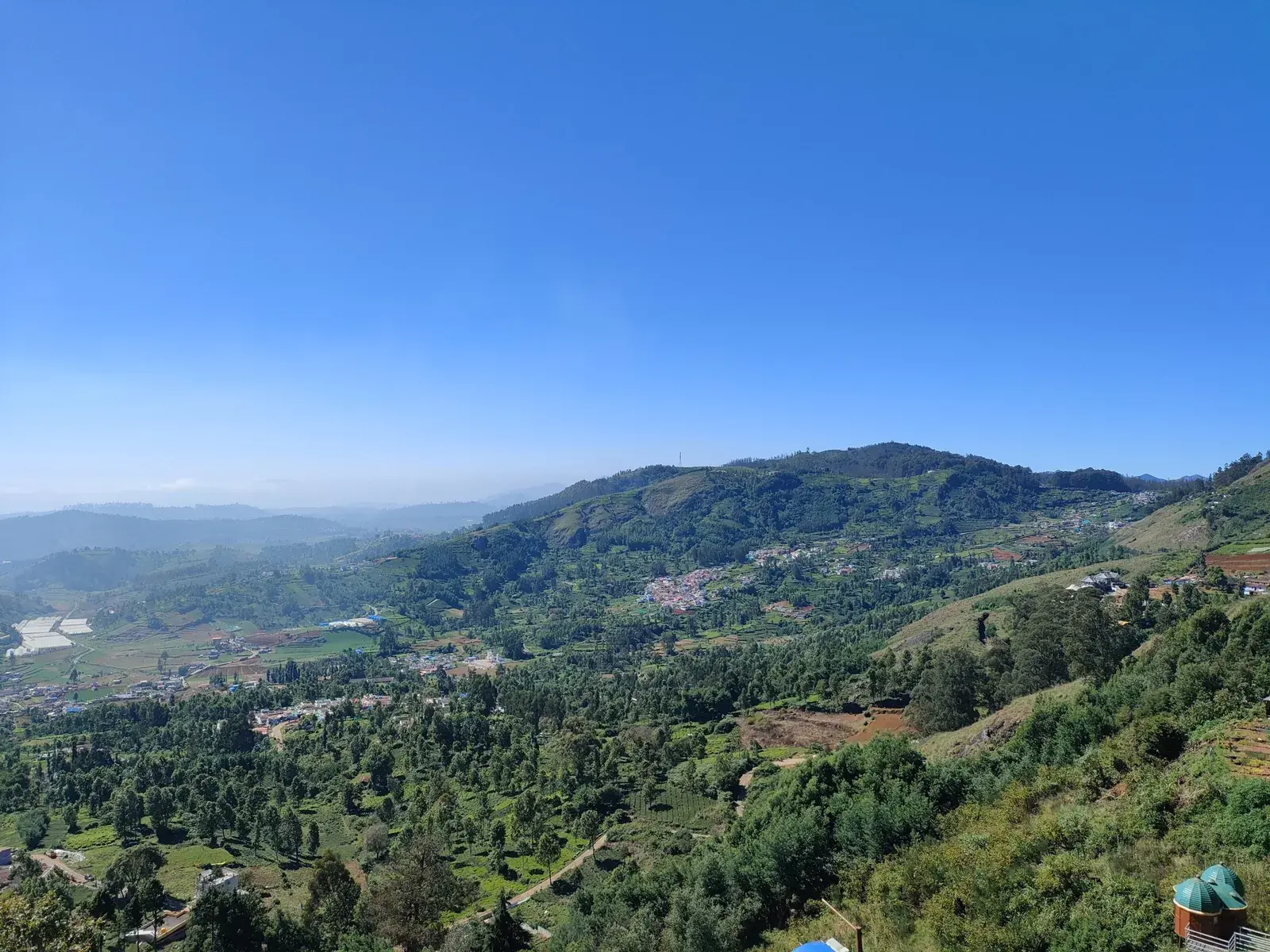 Green hills and valleys around Ooty under a clear blue sky