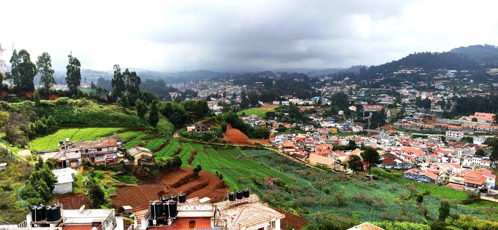 Colourful houses of Ooty town on terraced green hillsides